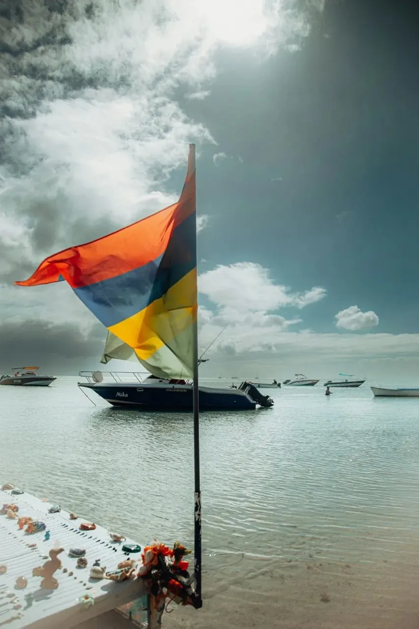Le drapeau mauricien flottant devant les bateaux du lagon